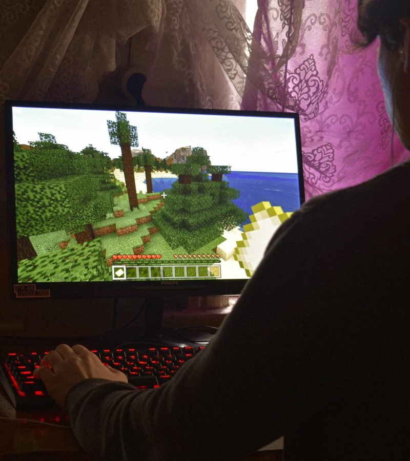 A young man intensely playing a PC video game indoors. Capturing the essence of technology and concentration.